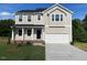 Charming two-story home features a two-car garage, black front door, and a well-manicured lawn at 119 Grove Township Way, Angier, NC 27501