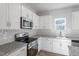 Bright kitchen showcases white cabinets, subway tile backsplash, stainless appliances, and granite counters at 119 Grove Township Way, Angier, NC 27501