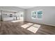 Open-concept living area with hardwood floors, kitchen view, and abundant natural light through large windows at 119 Grove Township Way, Angier, NC 27501