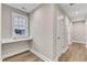 Hallway with wood floor and a window seating nook and storage at 1521 Chapel Hill Rd, Durham, NC 27701