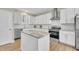 Bright kitchen featuring stainless steel appliances, white cabinets, subway tile backsplash, granite countertops, and an island at 1521 Chapel Hill Rd, Durham, NC 27701