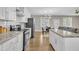 Open floor plan kitchen boasts stainless steel appliances, white cabinets, granite countertops, and hardwood floors at 1521 Chapel Hill Rd, Durham, NC 27701
