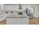 Bright kitchen featuring stainless steel appliances, subway tile backsplash, granite countertops, and a kitchen island at 1521 Chapel Hill Rd, Durham, NC 27701