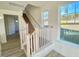 Carpeted staircase with white railings and wood banister, illuminated by a window at 169 Steel Springs Lane Rd # 17, Angier, NC 27501