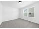 Simple bedroom with grey carpet, bright natural light, and a closet for storage at 185 Horseshoe Pl # 54, Angier, NC 27501