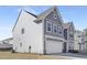 Side view of a grey home showcasing durable siding, a two-car garage, and a well-maintained yard at 185 Horseshoe Pl # 54, Angier, NC 27501