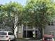 Two-story building exterior with balcony access in between, covered by trees and parked cars in front at 1911 Wolftech Ln # 303, Raleigh, NC 27603