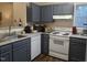 The gray kitchen features a sink, stove, dishwasher, and ample counter space with wood-look flooring at 1911 Wolftech Ln # 303, Raleigh, NC 27603