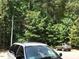 A wooded view of the parking lot with trees, with a minivan and SUV shown at 1911 Wolftech Ln # 303, Raleigh, NC 27603