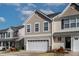Charming two-story home with a white garage door, neat landscaping and blue skies at 1952 Grassy Banks Dr, Raleigh, NC 27610