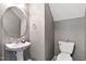 Clean powder room with pedestal sink, round mirror and tile flooring at 1952 Grassy Banks Dr, Raleigh, NC 27610