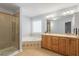 Bright bathroom featuring a soaking tub, glass shower, and wooden cabinets at 2030 Lonesome Dove Dr, Franklinton, NC 27525