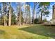 Spacious, shady backyard offers a tranquil escape surrounded by lush greenery and mature trees at 210 S General Lee Ave, Dunn, NC 28334