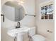 Charming bathroom featuring a pedestal sink, toilet, and a window for natural light at 210 S General Lee Ave, Dunn, NC 28334