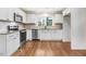 Modern kitchen features white cabinetry, stainless steel appliances, and wood floors at 210 S General Lee Ave, Dunn, NC 28334