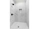 Elegant walk-in shower featuring white marble-patterned tile and a convenient built-in niche at 210 S General Lee Ave, Dunn, NC 28334