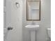 Clean and modern half-bathroom with a pedestal sink, gold mirror, and neutral decor at 2156 Pink Peony Cir # 157, Durham, NC 27703