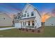 Beautiful home exterior with brick and white siding, accented by blue shutters and a well-maintained green lawn at 2156 Pink Peony Cir # 157, Durham, NC 27703