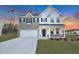 Charming two-story home features a brick and white facade, complemented by blue shutters and a well-manicured lawn at 2156 Pink Peony Cir # 157, Durham, NC 27703