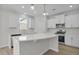 Modern kitchen boasts white cabinetry, stainless steel appliances, a spacious island, and hardwood floors at 2156 Pink Peony Cir # 157, Durham, NC 27703