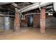 Unfinished basement featuring exposed brick, utilities and a small door, perfect for extra storage space at 221 Charlotte Ave, Sanford, NC 27330