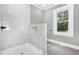 This renovated bathroom features a marble shower, recessed niche, and natural light at 221 Charlotte Ave, Sanford, NC 27330