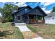 Charming two-story home with a covered front porch, a brick walkway, and a landscaped yard at 221 Charlotte Ave, Sanford, NC 27330