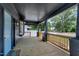 The home's covered front porch with wood flooring, railings, and view of the surrounding neighborhood at 221 Charlotte Ave, Sanford, NC 27330