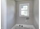 An unfinished laundry room with washer and dryer hookups and tile floor, awaiting your customization at 221 Charlotte Ave, Sanford, NC 27330