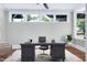 Office with dark wood desk, neutral rug, and natural light from surrounding windows at 221 Charlotte Ave, Sanford, NC 27330
