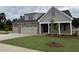 Charming home with a three car garage, gray and brick exterior, and a manicured front lawn at 2328 Eagle Shot Ct # 18, Fuquay Varina, NC 27526