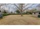 Large backyard with grass, small sheds, trees, and trimmed hedges surrounding the border at 2720 Amherst Ave, Burlington, NC 27215