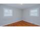 A bedroom features hardwood floors, neutral-painted walls, and two windows at 2720 Amherst Ave, Burlington, NC 27215