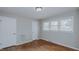 Bedroom featuring hardwood floors, neutral-painted walls, and three windows at 2720 Amherst Ave, Burlington, NC 27215