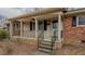 Inviting front porch with brick supports, black railings, and neutral siding at 2720 Amherst Ave, Burlington, NC 27215