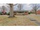 Traditional brick house with mature trees and a concrete walkway at 2720 Amherst Ave, Burlington, NC 27215
