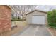 View of the detached garage, with a paved driveway and a green backyard at 2720 Amherst Ave, Burlington, NC 27215