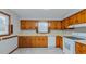 Traditional kitchen featuring wood cabinets, white appliances, a double-basin sink, and natural light at 2720 Amherst Ave, Burlington, NC 27215