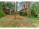 Secluded backyard with mature trees, a brick home, wooden shed, and lush landscaping at 2930 Hostetler St, Raleigh, NC 27609