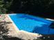 Refreshing in-ground pool with brick surround and mature landscaping providing a private backyard oasis at 2930 Hostetler St, Raleigh, NC 27609
