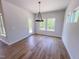 Open dining room with hardwood floors, large windows and modern chandelier at 394 Duncan Creek Rd # 158, Lillington, NC 27546
