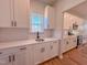 Well-lit kitchen features white cabinets, quartz counters, subway tile, stainless steel appliances, and wood-look flooring at 394 Duncan Creek Rd # 158, Lillington, NC 27546