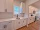 Well-lit kitchen features white cabinets, quartz counters, subway tile, stainless steel appliances, and wood-look flooring at 394 Duncan Creek Rd # 158, Lillington, NC 27546