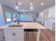 Spacious kitchen with white cabinets, quartz countertops, a stainless steel dishwasher, and a central island at 394 Duncan Creek Rd # 158, Lillington, NC 27546