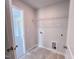 Tiled laundry room equipped with essential connections and shelving for added convenience at 394 Duncan Creek Rd # 158, Lillington, NC 27546