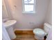 The powder room includes a pedestal sink and modern toilet with wood flooring at 394 Duncan Creek Rd # 158, Lillington, NC 27546