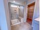 Close-up of tiled shower with glass door, seating, and small window at 394 Duncan Creek Rd # 158, Lillington, NC 27546