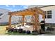 Enjoy the patio with wood pergola, grill, and lush potted plants for a perfect outdoor experience at 405 Joseph Alexander Dr, Fuquay Varina, NC 27526