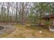 A backyard pool surrounded by brick patio, mature trees and a glimpse of the brick house at 407 Granville Rd, Chapel Hill, NC 27514