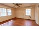 Spacious bedroom featuring hardwood floors, a ceiling fan, and natural light from two large windows at 407 Granville Rd, Chapel Hill, NC 27514
